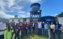 Grupo de pessoas ao lado de uma caixa d'água